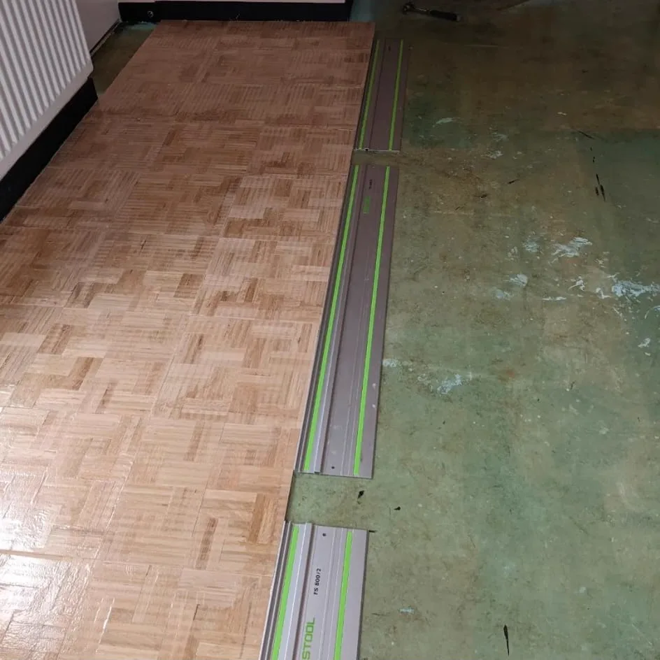 New oak finger mosaic parquet being laid over a DPM-primed subfloor in a Chipstead CR5 home by Howard Naish