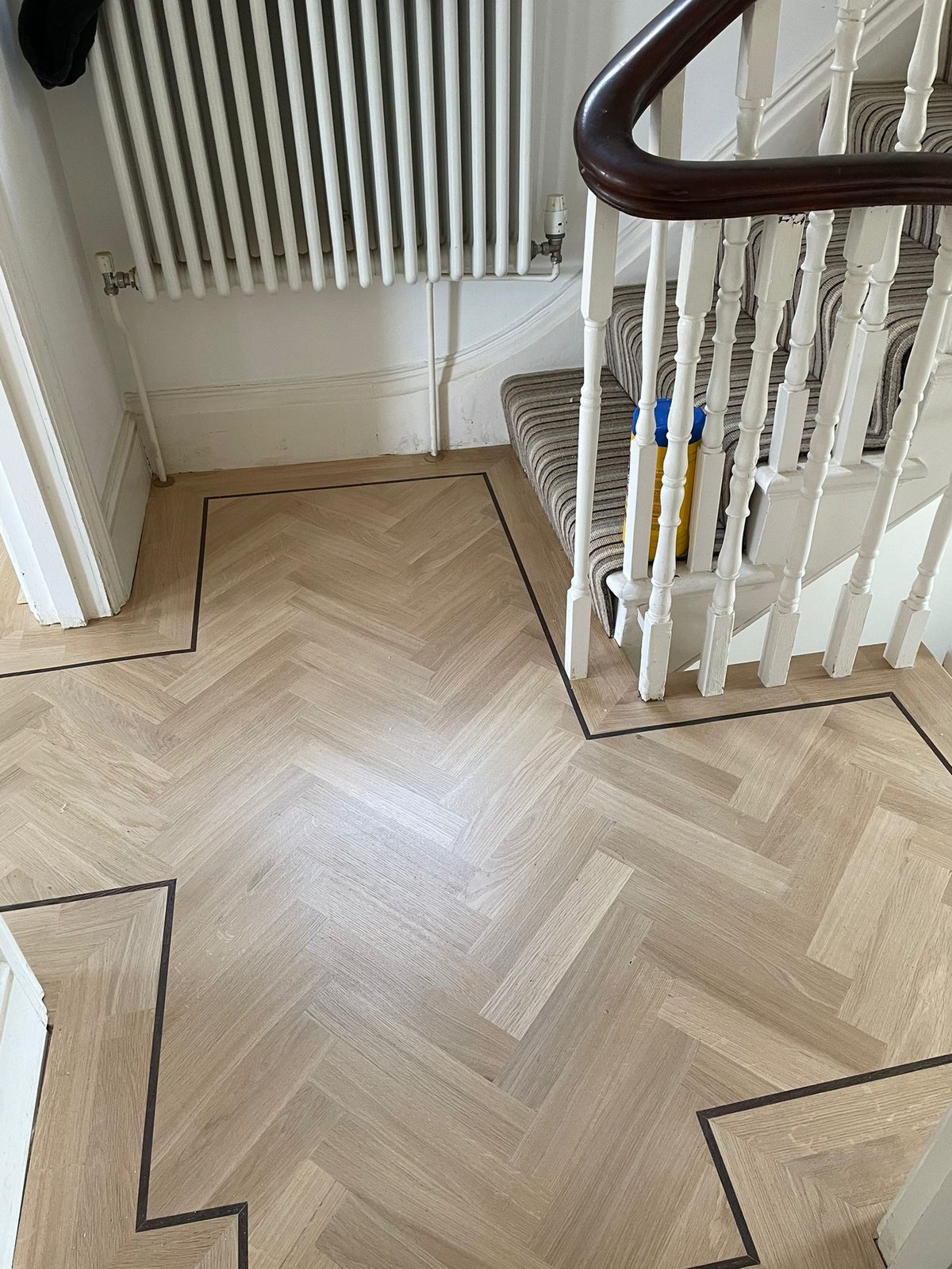 Herringbone parquet hallway with painted stairs in Clapham SW4