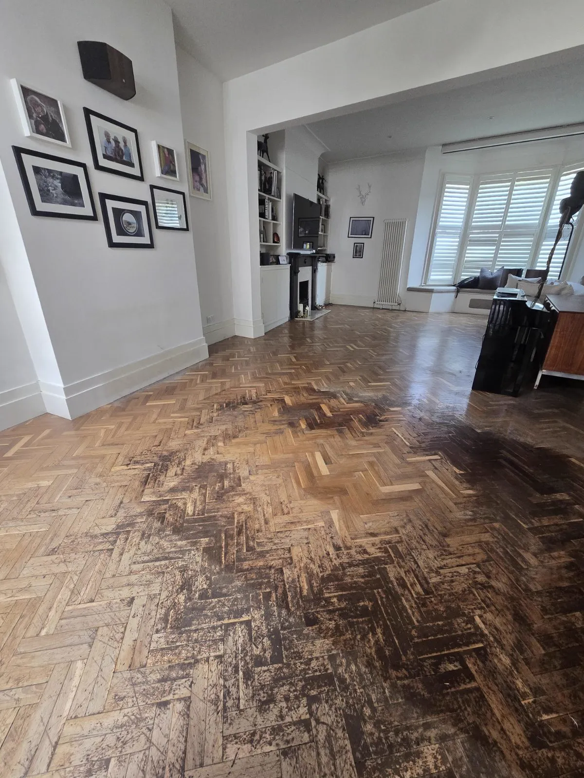 Tired original herringbone parquet before restoration, worn finish and dulled blocks