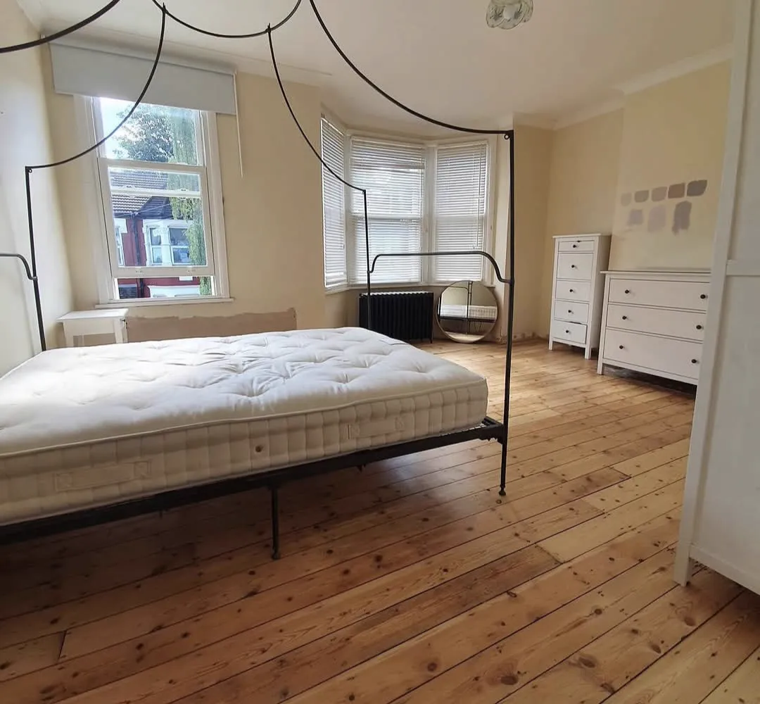 Restored honey pine floorboards in a Crystal Palace bedroom after sanding by Howard Naish