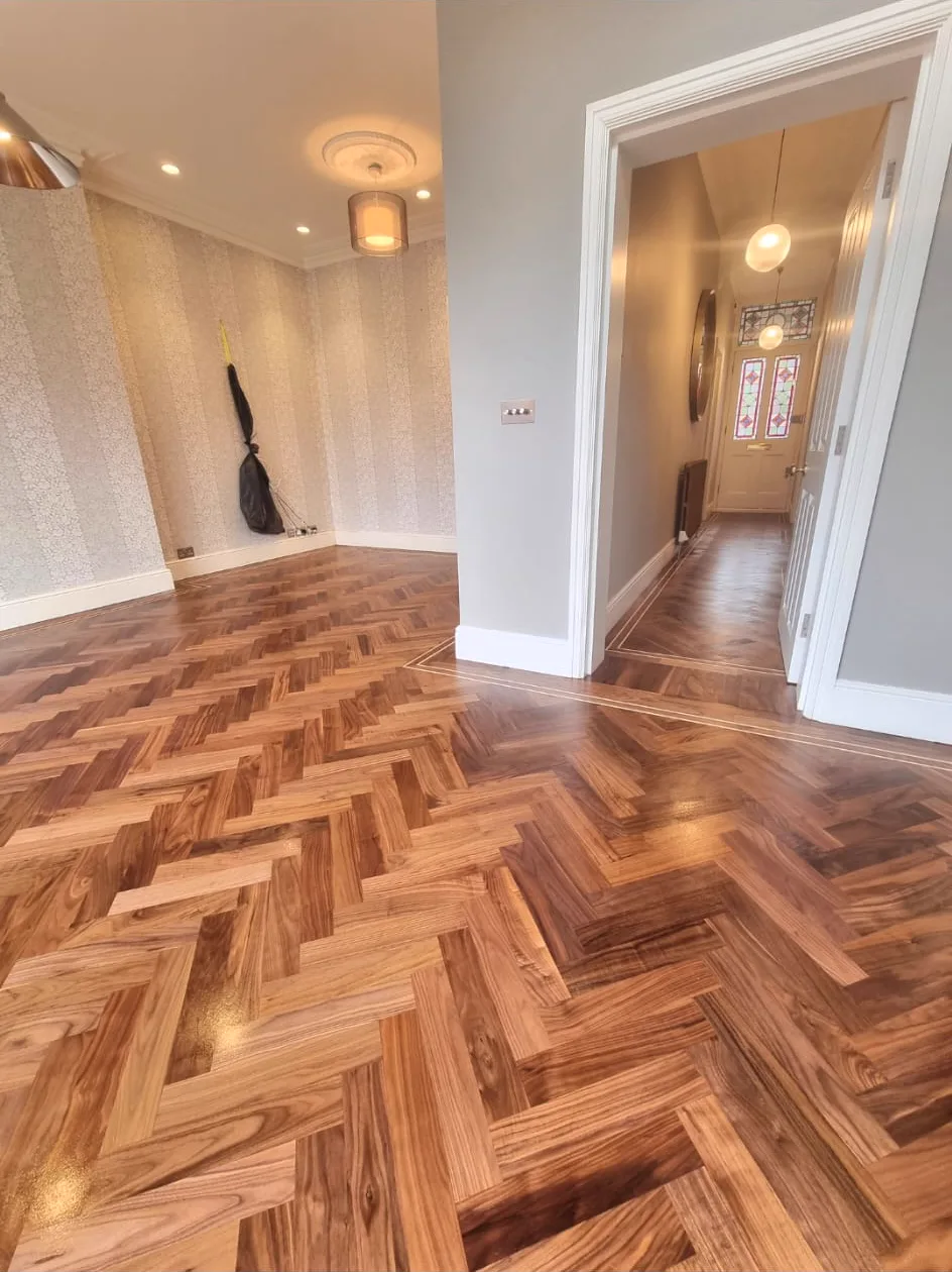 Restored walnut herringbone floor with inlay border in a Fulham SW6 reception by Howard Naish