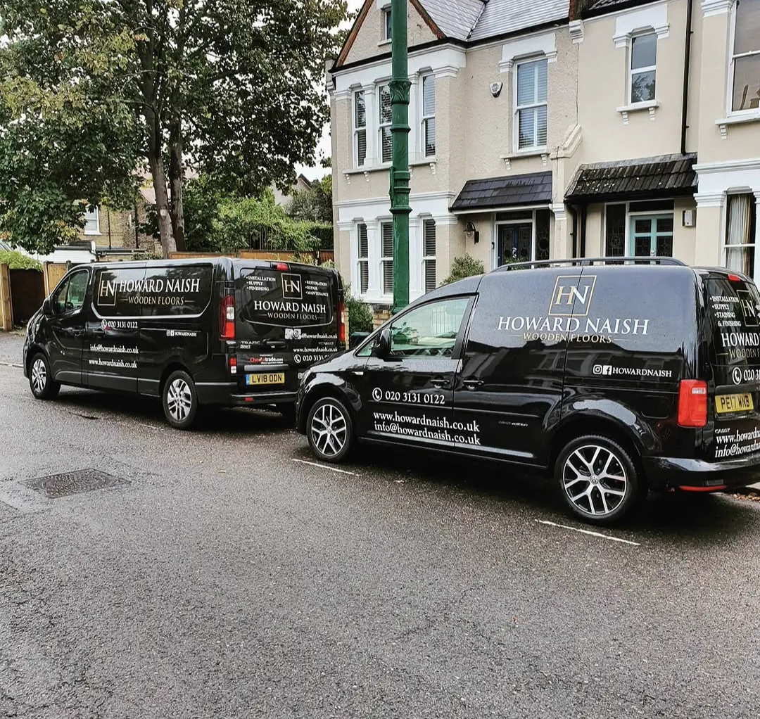The two black Howard Naish vans parked side by side outside a South London period house