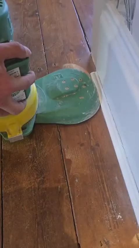 The Lagler Flip edge sander working along a skirting board with its dust extraction hose attached