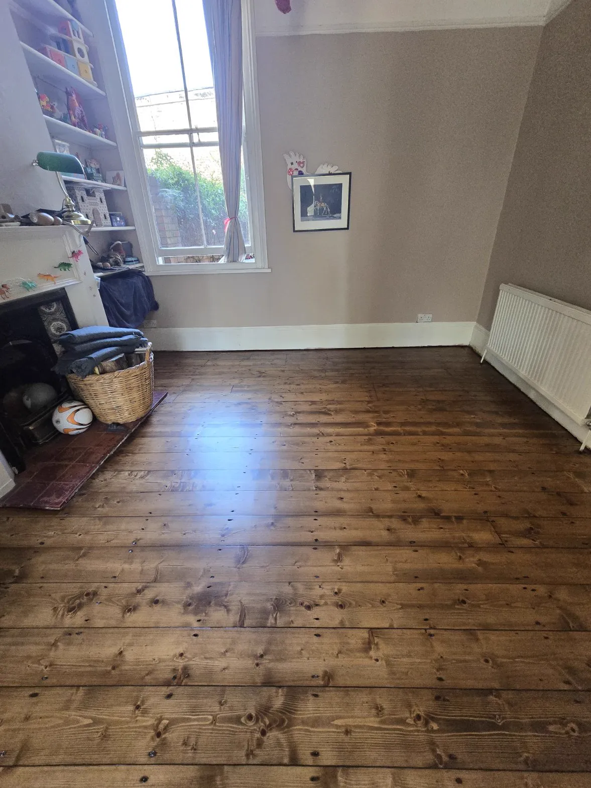 Original pine floorboards in a Streatham Hill family room, sanded and stained a deep even brown by Howard Naish