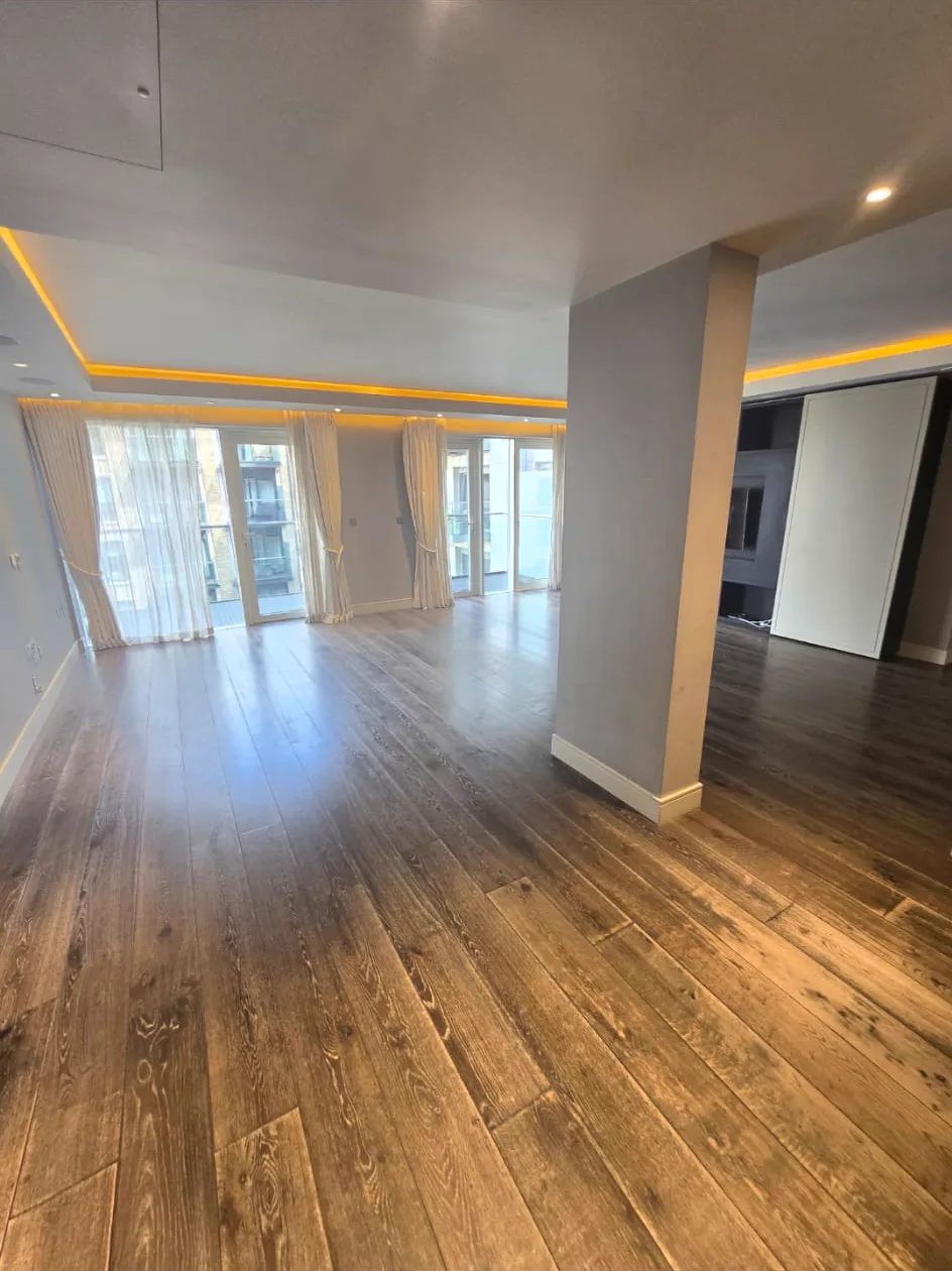 Main open-plan living floor in a Putney SW15 apartment, dark and worn before sanding