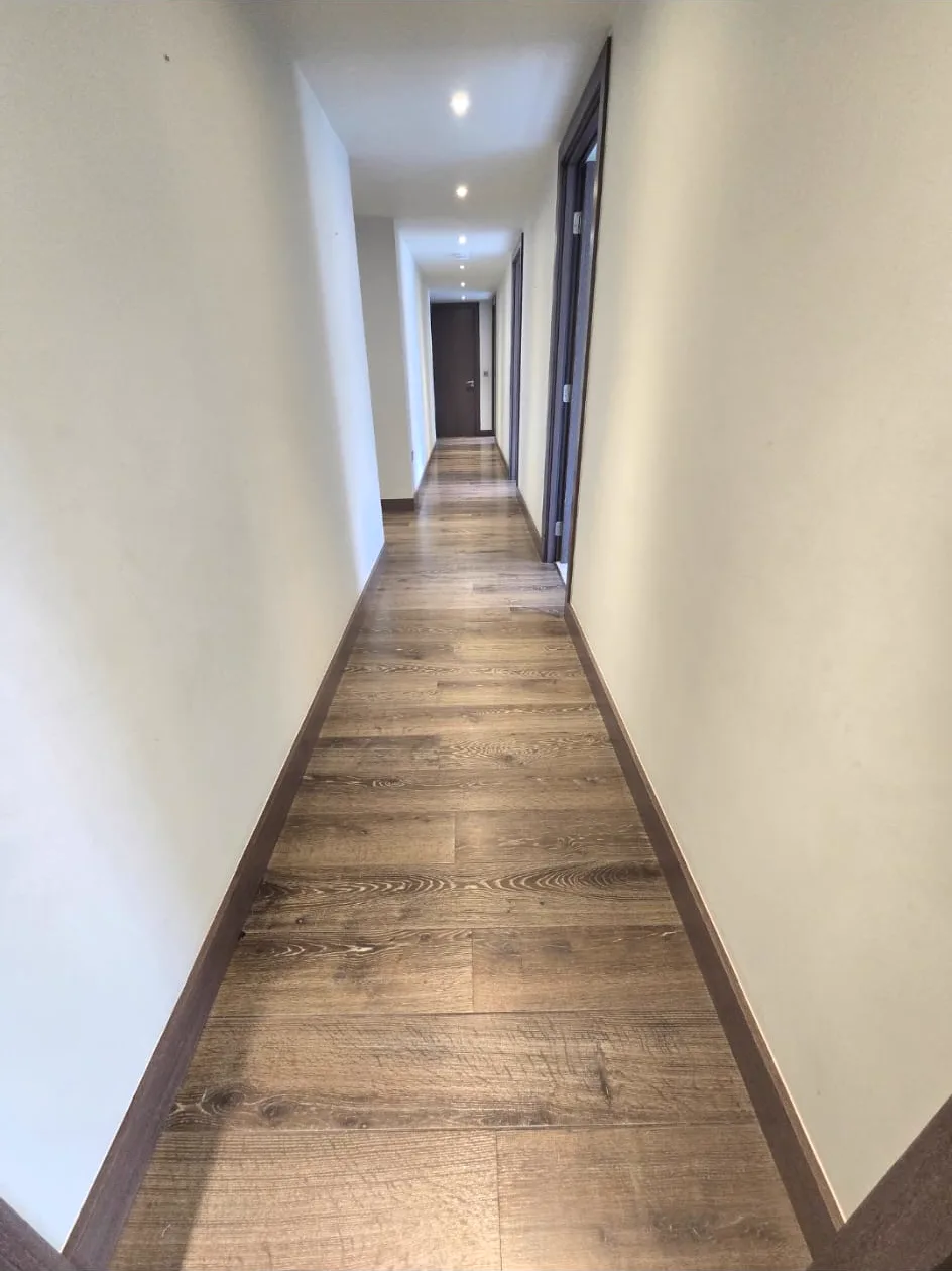 Hallway floor in a Putney SW15 apartment, dark and dull before sanding