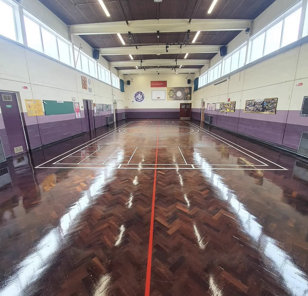 Restored herringbone parquet sports floor with court lines in a Scout hall, refinished by Howard Naish