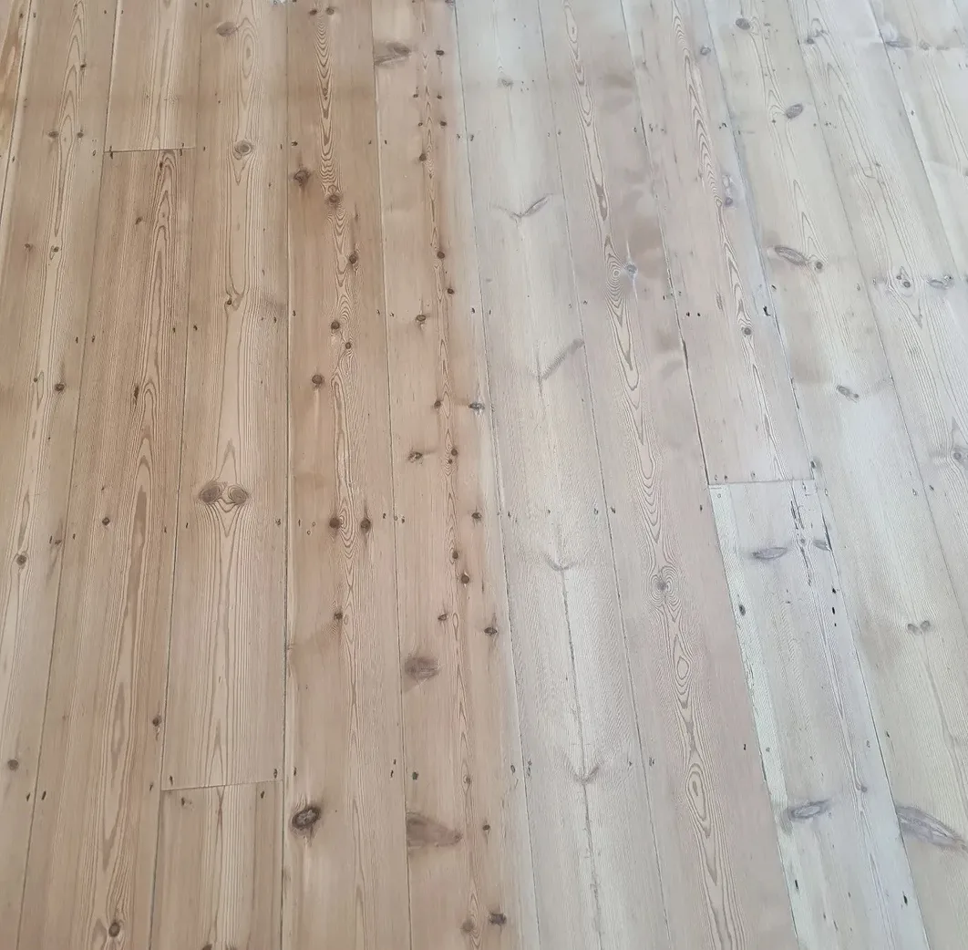Pine floor mid-finish with orange boards on one side and light white-finished boards on the other