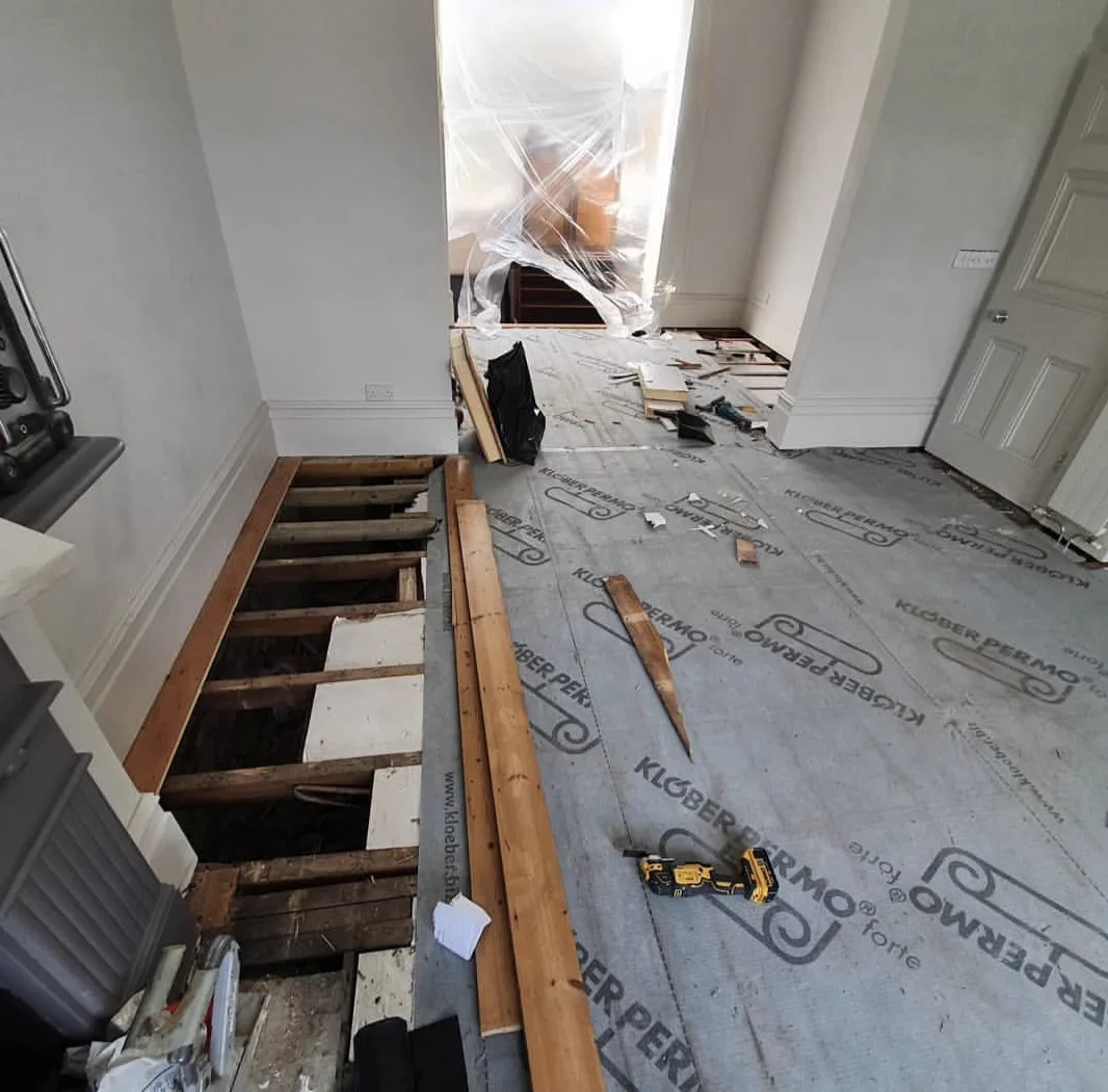 Old floorboards stripped out and a breathable membrane laid between the joists during a South London floor renovation by Howard Naish